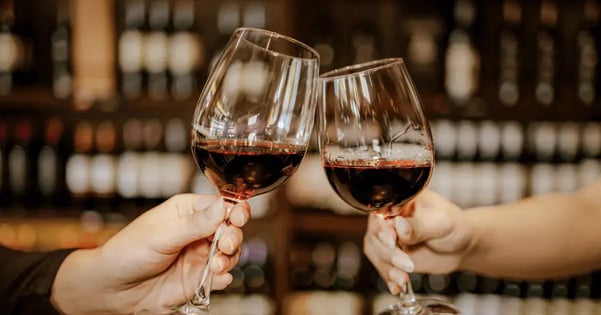 two people clicking wine glasses